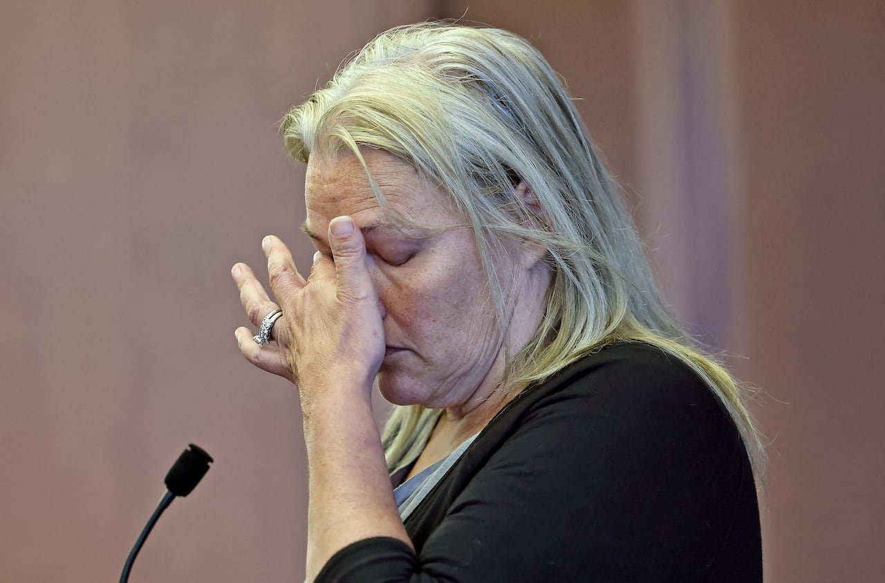 default-451 A woman rubs her face standing in a court room