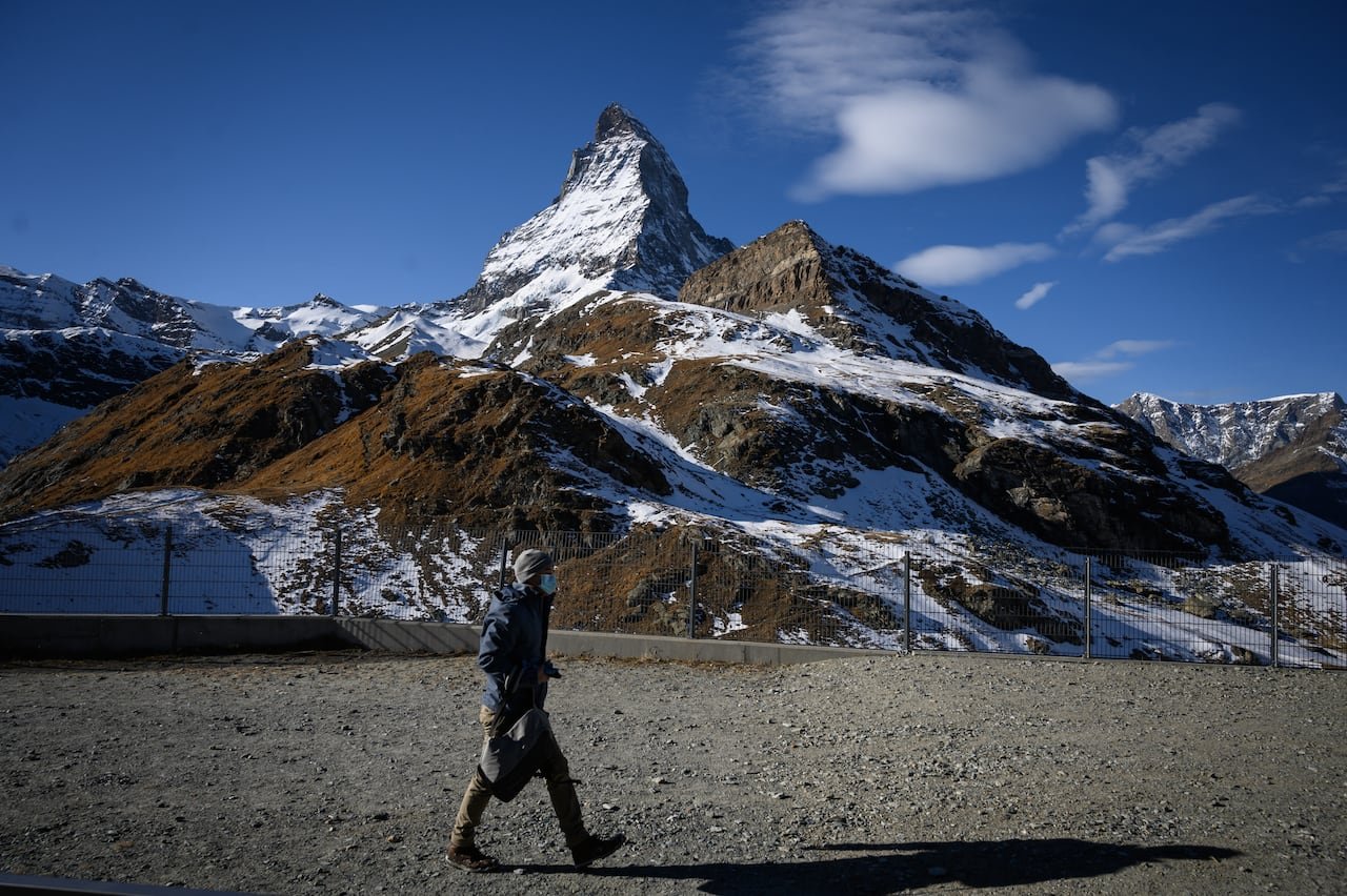 default-590 A person walks along a path with a mountain in the background.